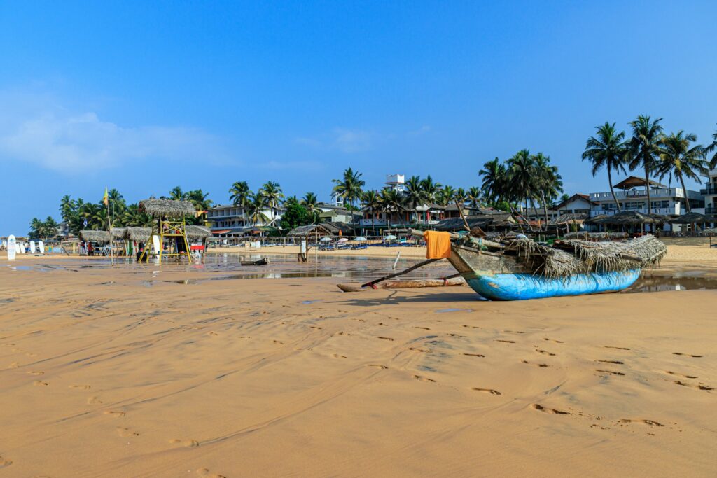 a boat sitting on top of a sandy beach